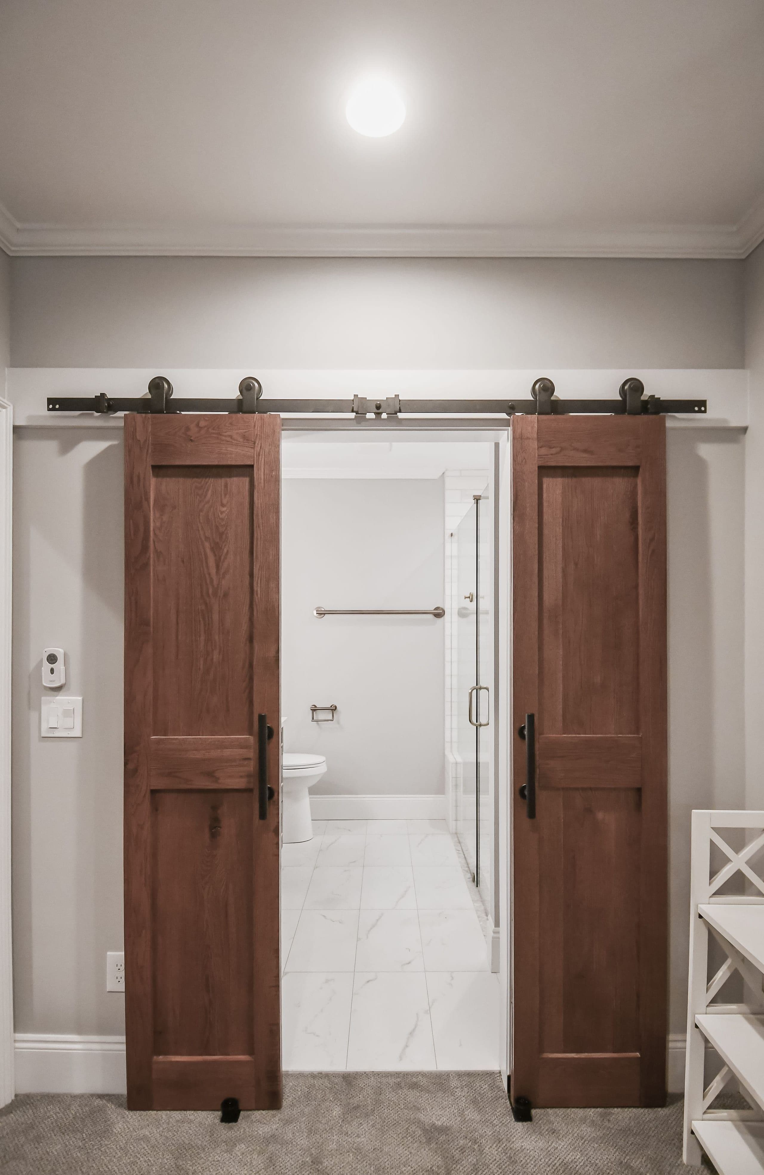 Finished basement suite with a bath behind custom sliding barn doors